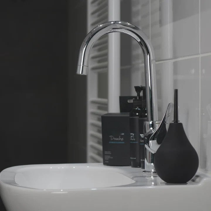 Bathroom sink with modern faucet and black toiletries featuring Nexus Anal Douche Non Return Valve 224ml sitting upright