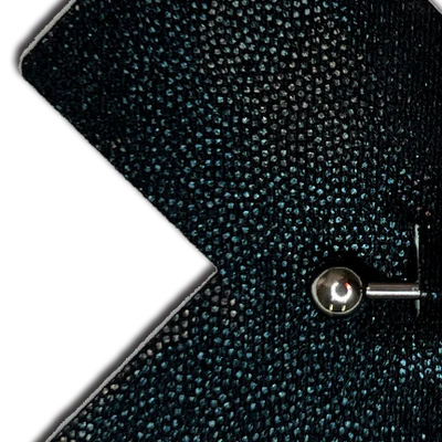 Close-up of a textured black surface of Pastease liquid black cross plus barbell nipple cover with a metallic stud.