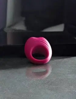 Maroon Dusk Till Dawn ring by Pure Romance on reflective surface.