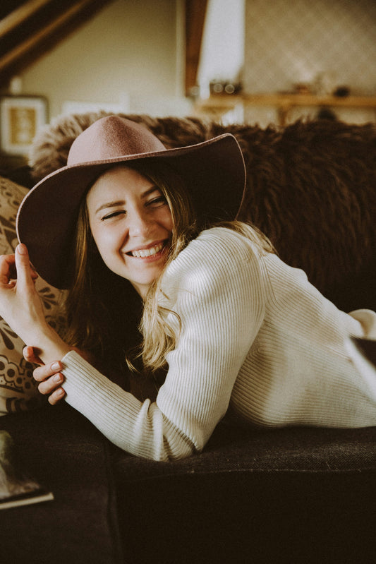woman in cowboy hat on couch smiling