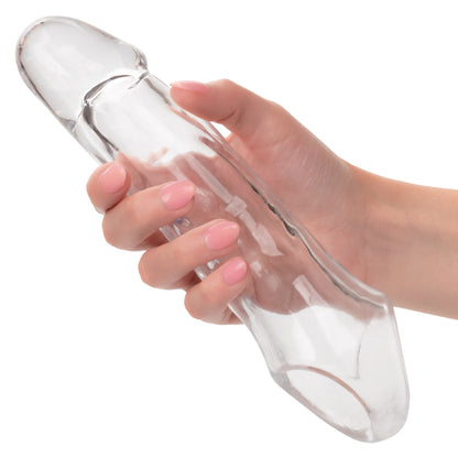 Woman holding Calexotics Performance Maxx clear 7.5-inch penis extender in her hand, showing soft, flexible texture and realistic detailing for visual scale and product feel.