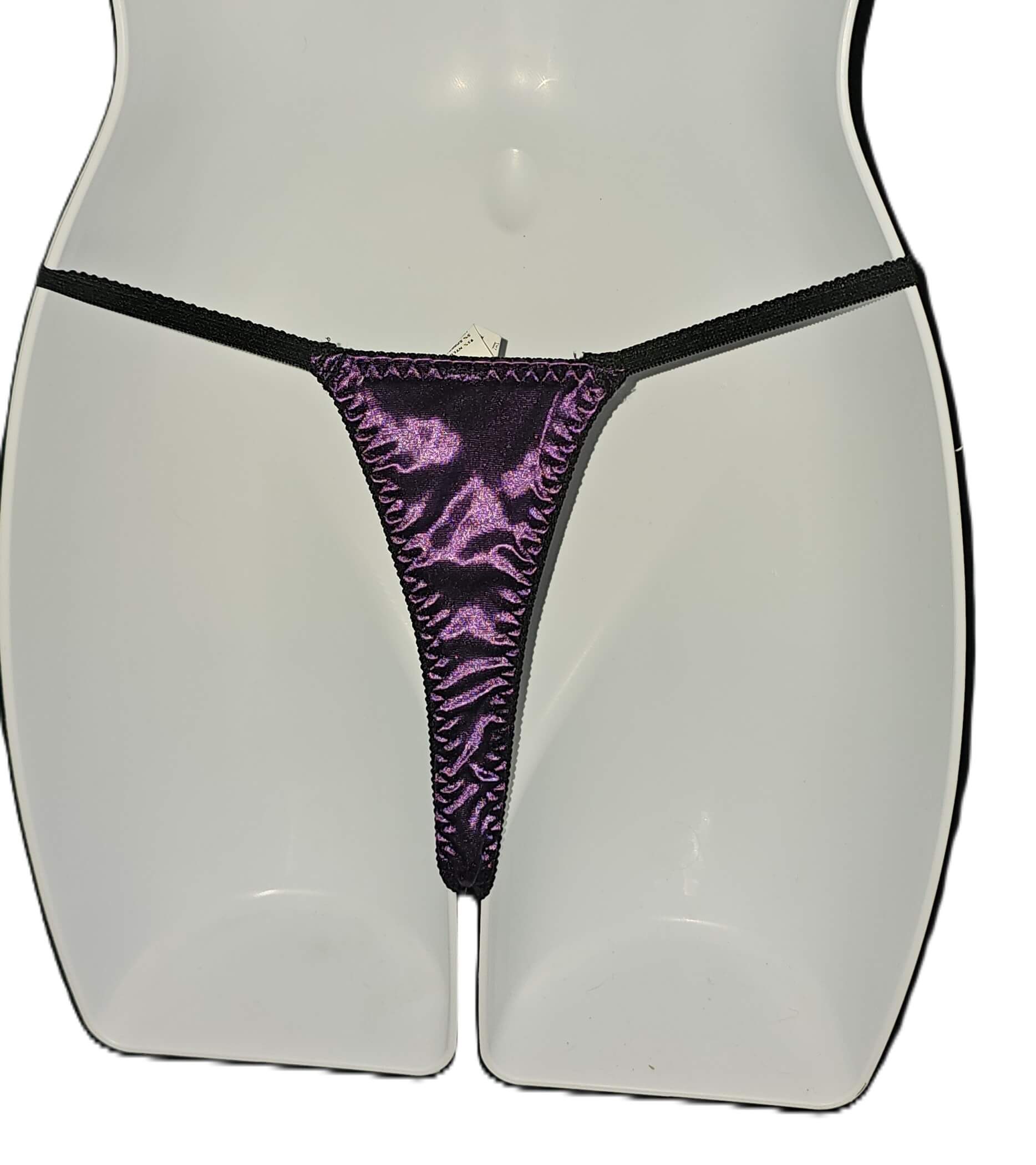 A close-up of a mannequin torso wearing a thong-style underwear bottom with a shiny purple front panel and black side straps and trim, against a plain white background. Escante Luxury Lace Purple Babydoll Dress with Matching Thong - Medium