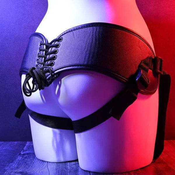 Black lace-up garter belt on a mannequin against a colorful background featuring Evolved Novelties Heavenly Harness
