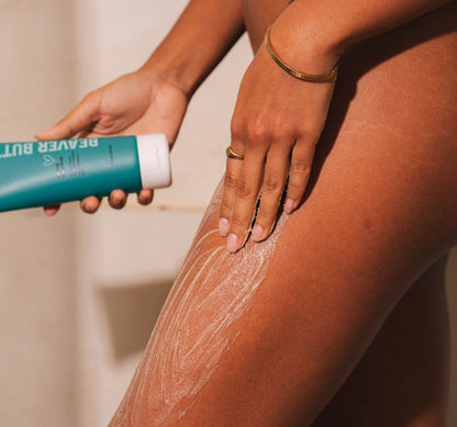 Person applying a Beaver Butter Cream Body Buffing Polish to their leg with a focus on the application process.