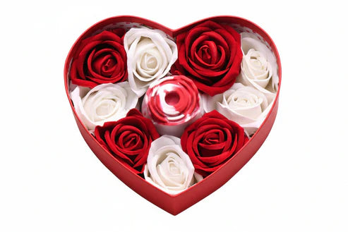 Red Heart-shaped box filled with red and white roses, with a smaller heart-shaped red rose vibrator in the middle on a white background