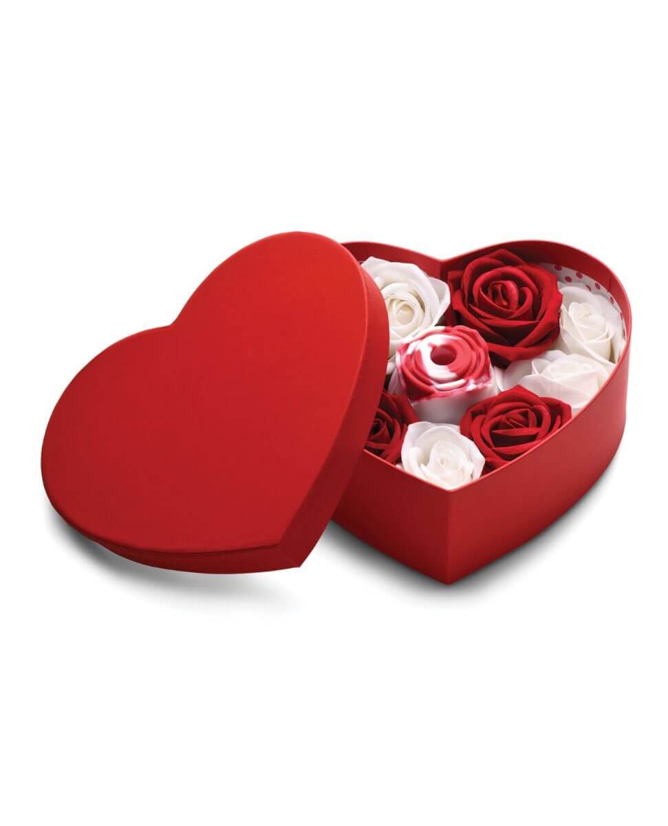 Heart-shaped red box with red and white artificial roses and a rose-shaped vibrator on a white background