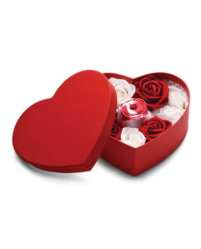 Heart-shaped red box with red and white artificial roses and a rose-shaped vibrator on a white background