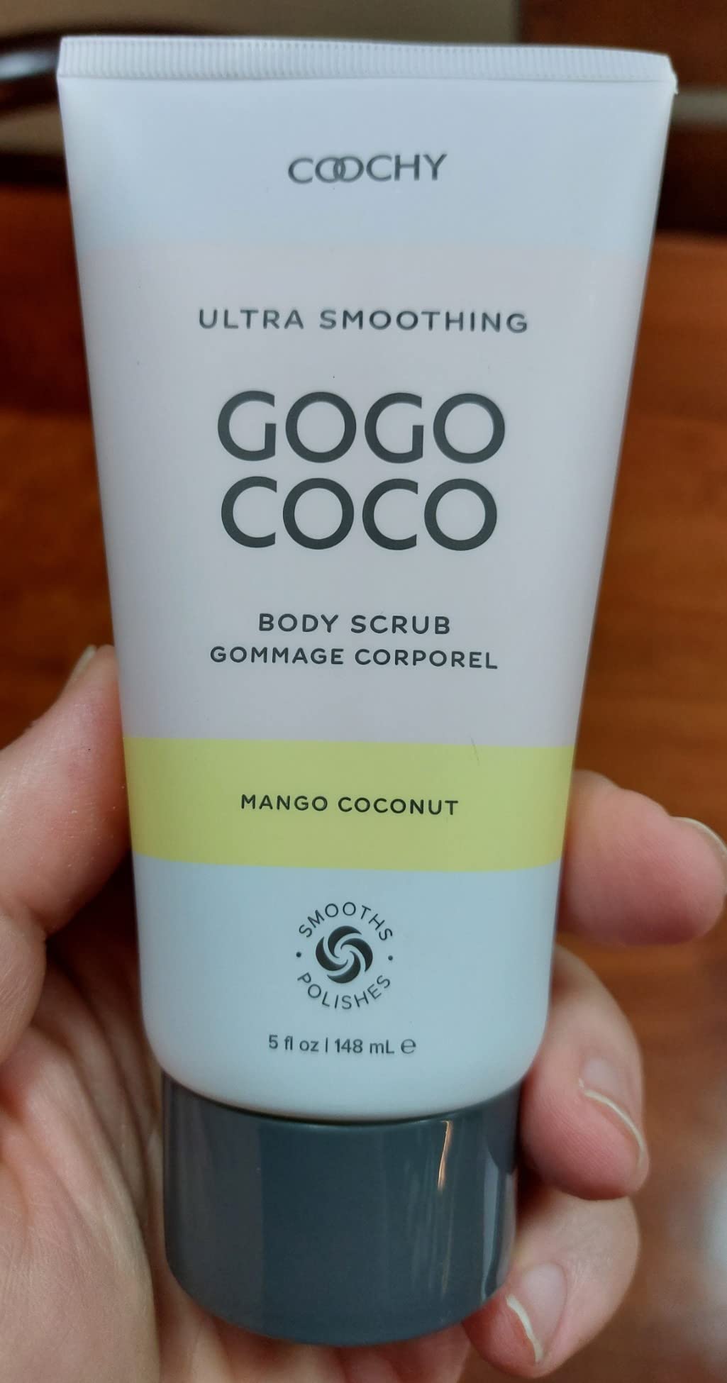 Cocochy ultra smoothing body scrub with mango coconut scent held in a hand.