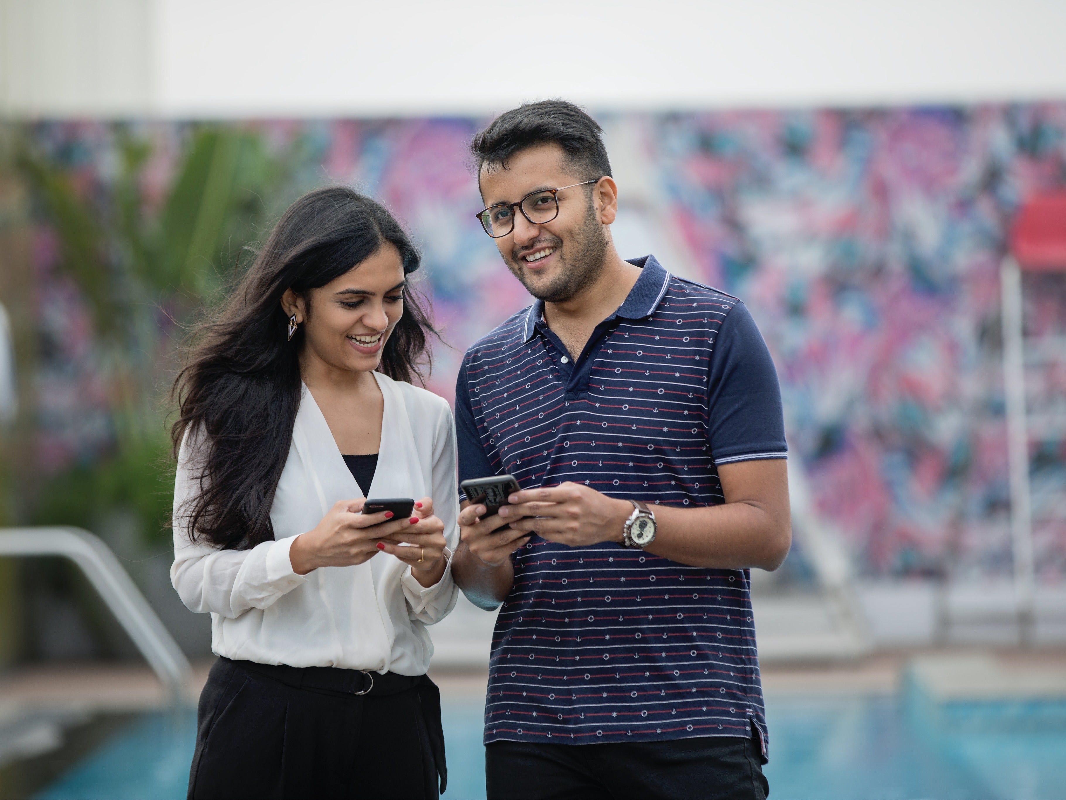 Couple sharing a discount code on a smartphone for a referral program to share with a friend, get rewards, adult lifestyle promotion.