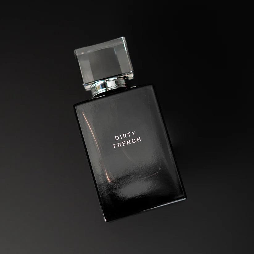 Black perfume bottle by Pure Romance  labeled 'Dirty French' on a black background