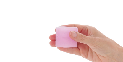 Hand holding X5 Men Goin' Down pink BJ Masturbator silicone oral sex and bj enhancer on a white background