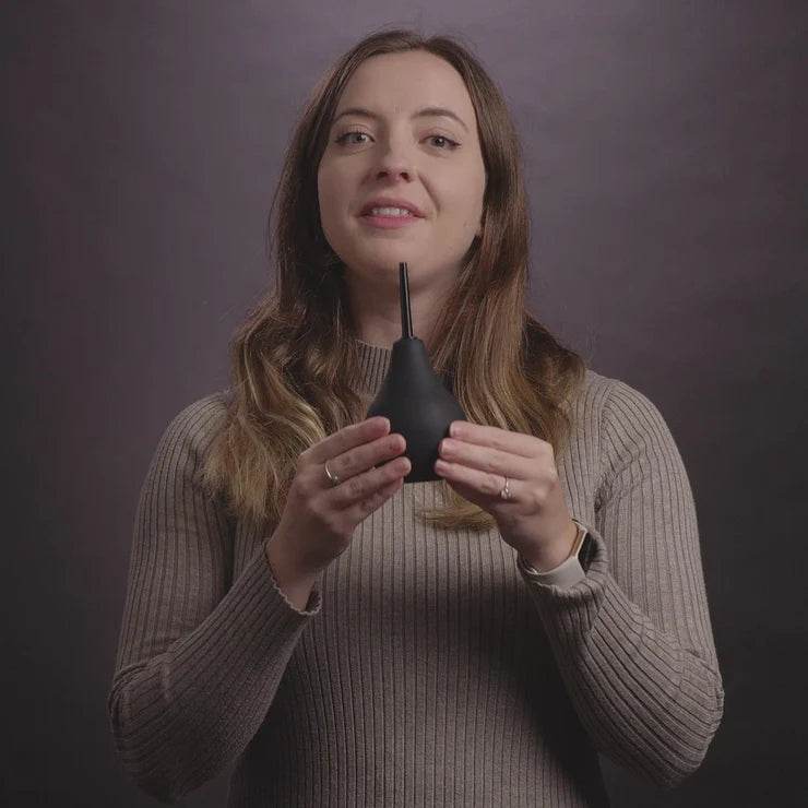 Woman in sweater holding Nexus Anal Douche Non Return Valve 224ml