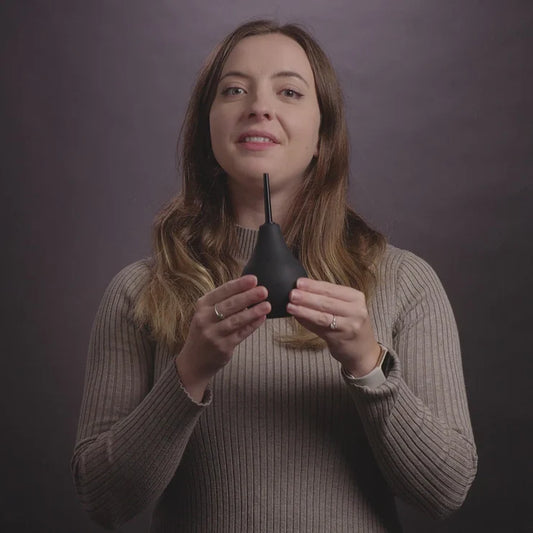 Woman in sweater holding Nexus Anal Douche Non Return Valve 224ml