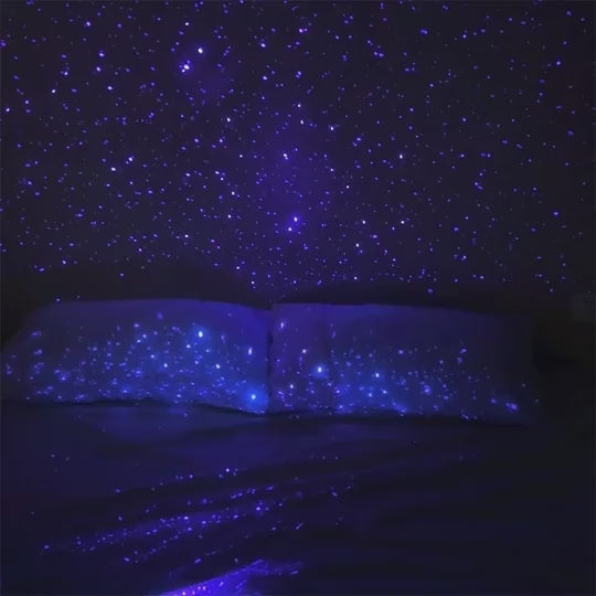 Svakom Pulse Galaxie clitoral air pulse technology stimulator with starlight projector video in a dark room projecting white stars on bed and wall
