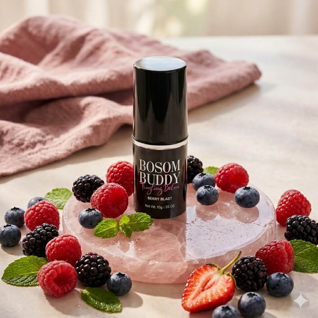 Pure Romance Bosom Buddy tingling lip balm Berry Blast black container featured on pink stone with mixed berries and mint leaves with fabric blurred in the background