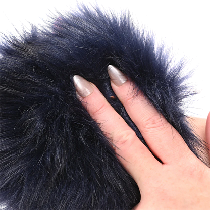 Close-up of a hand with a manicured nail touching black faux fur Sportsheets Cougar Spiked Glove.
