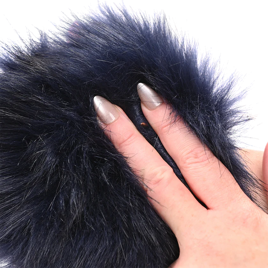 Close-up of a hand with a manicured nail touching black faux fur Sportsheets Cougar Spiked Glove.