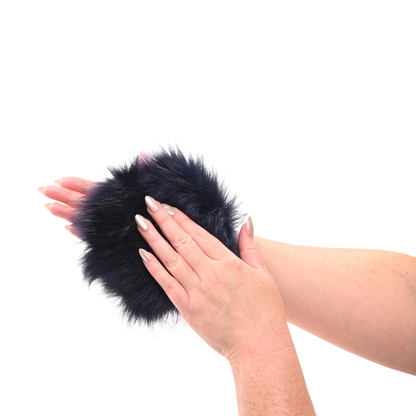 Sportsheets cougar spiked sensory glove in Black like fur pom-pom mitten with hidden spikes held between two hands on a white background