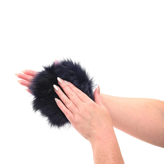 Sportsheets cougar spiked sensory glove in Black like fur pom-pom mitten with hidden spikes held between two hands on a white background
